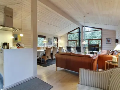 a living room with chairs and a dining room at Holiday Home Jo - 1-2km from the sea by Interhome in Løkken