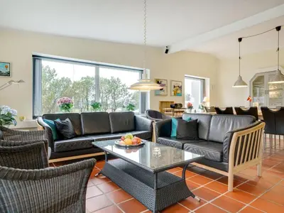 a living room with a couch and a table at Holiday Home Lenni - 700m from the sea by Interhome in Løkken