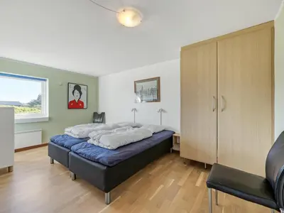 a bedroom with a bed and a cabinet and a window at Holiday Home Lenni - 700m from the sea by Interhome in Løkken