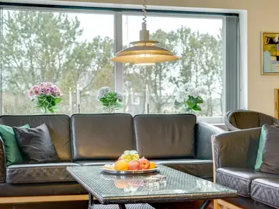 a living room with a couch and a table with fruit on it at Holiday Home Lenni - 700m from the sea by Interhome in Løkken