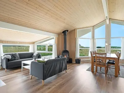 a living room with a couch and a fireplace at Holiday Home Katla - 400m from the sea by Interhome in Løkken