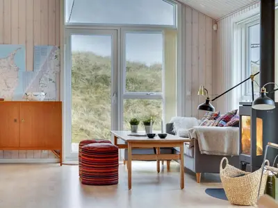 a living room with a table and a couch at Holiday Home Marthine - 200m from the sea by Interhome in Løkken
