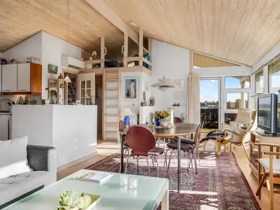 a kitchen and living room with a table and chairs at Holiday Home Ofrath - 350m from the sea by Interhome in Løkken