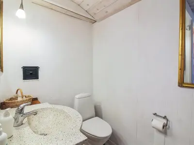 a white bathroom with a sink and a toilet at Holiday Home Trude - 250m from the sea by Interhome in Løkken