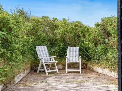 two chairs sitting next to each other on a walkway at Holiday Home Thorfrid - 150m from the sea by Interhome in Løkken