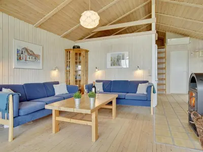 a living room with blue couches and a table at Holiday Home Viktoria - 400m from the sea by Interhome in Løkken