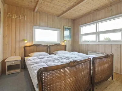 a bedroom with two beds and two windows at Holiday Home Viktoria - 400m from the sea by Interhome in Løkken