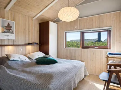 a bedroom with a bed with a large window at Holiday Home Danica - 175m from the sea by Interhome in Løkken