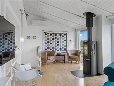 a living room with a wood stove in the middle at Holiday Home Stina - 250m from the sea by Interhome in Løkken