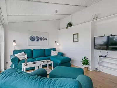 a living room with a blue couch and a table at Holiday Home Stina - 250m from the sea by Interhome in Løkken