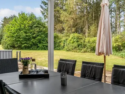 a table with an umbrella on a patio at Holiday Home Dimo - 700m from the sea by Interhome in Løkken