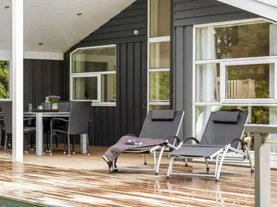 a patio with chairs and a table on a house at Holiday Home Dimo - 700m from the sea by Interhome in Løkken