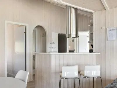 a dining room with two white chairs and a table at Holiday Home Solvejg - 150m from the sea by Interhome in Løkken