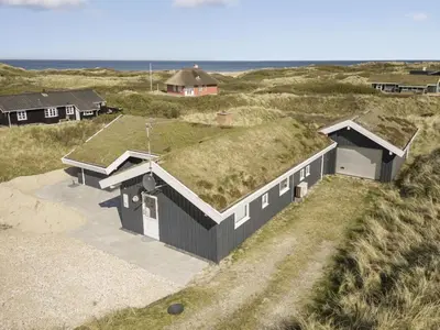 a house with a grass roof on the beach at Holiday Home Solvejg - 150m from the sea by Interhome in Løkken