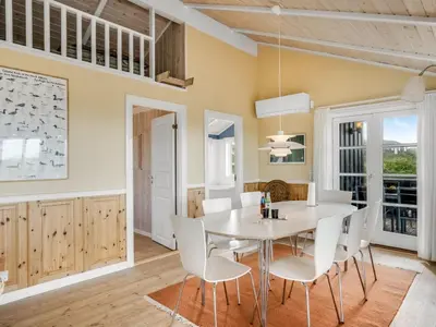 a dining room with a white table and chairs at Holiday Home Kasperi - 250m from the sea by Interhome in Løkken