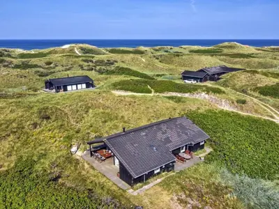 an aerial view of two houses on a hill with the ocean at Holiday Home Åmunde - 150m from the sea by Interhome in Løkken