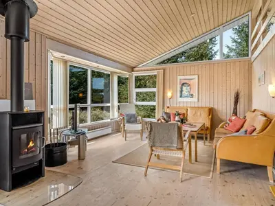 a living room with a fireplace and a stove at Holiday Home Terho - 1km from the sea by Interhome in Løkken