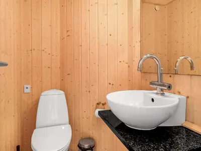 a bathroom with a white sink and a toilet at Holiday Home Terho - 1km from the sea by Interhome in Løkken
