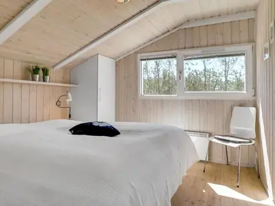 a bedroom with a large white bed and a window at Holiday Home Gorica - 450m from the sea by Interhome in Løkken