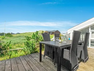 a table and chairs on a deck with a view at Holiday Home Gorica - 450m from the sea by Interhome in Løkken