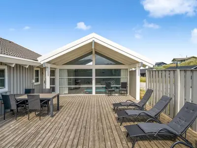 a deck with chairs and a table on a house at Holiday Home Anne - 100m from the sea by Interhome in Løkken