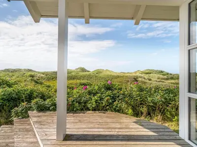 a view from the porch of a house with a wooden walkway at Holiday Home Anne - 100m from the sea by Interhome in Løkken