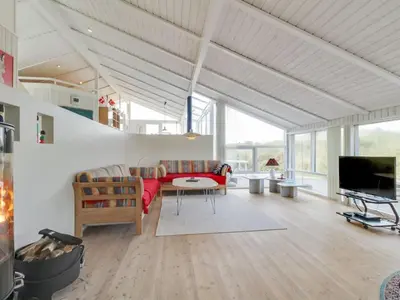 a living room with a couch and a table at Holiday Home Avni - 200m from the sea by Interhome in Løkken