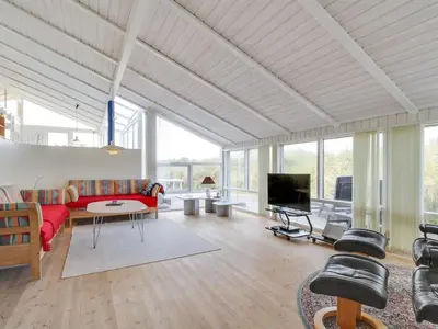 a living room with a red couch and a tv at Holiday Home Avni - 200m from the sea by Interhome in Løkken