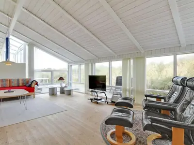 a living room with a couch and chairs and a tv at Holiday Home Avni - 200m from the sea by Interhome in Løkken