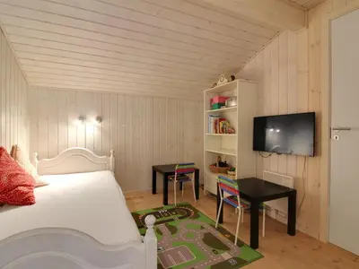 a bedroom with a bed and a desk and a tv at Holiday Home Siljana - 1km from the sea by Interhome in Løkken