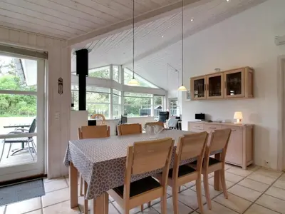 a kitchen and dining room with a table and chairs at Holiday Home Siljana - 1km from the sea by Interhome in Løkken