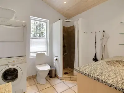 a white bathroom with a toilet and a shower at Holiday Home Siljana - 1km from the sea by Interhome in Løkken
