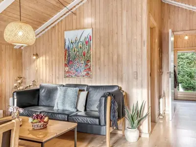 a living room with a couch and a table at Holiday Home Seda - 600m from the sea by Interhome in Løkken