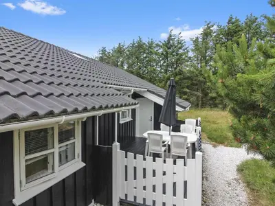 a house with a white fence and an umbrella at Holiday Home Jens - 425m from the sea by Interhome in Løkken