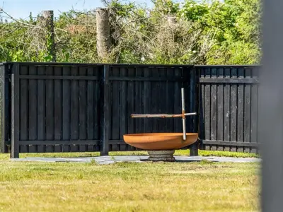 a toilet sitting in a yard next to a fence at Holiday Home Guja - 1km from the sea by Interhome in Løkken