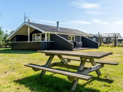 a picnic table in front of a house at Holiday Home Guja - 1km from the sea by Interhome in Løkken