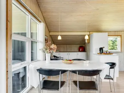 a kitchen with a white table and chairs at Holiday Home Guja - 1km from the sea by Interhome in Løkken