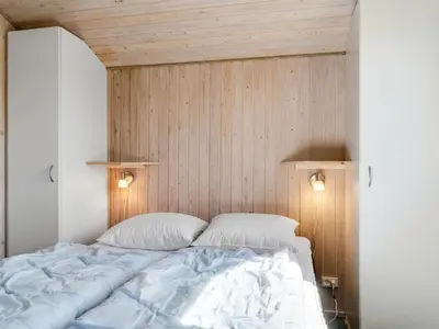 a bedroom with a large bed with two pillows at Holiday Home Guja - 1km from the sea by Interhome in Løkken