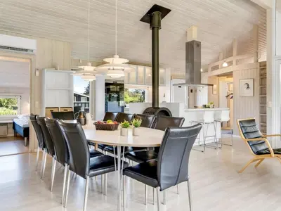a dining room and kitchen with a table and chairs at Holiday Home Aponi - 400m from the sea by Interhome in Løkken