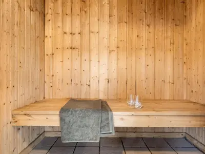 a wooden bench in a sauna with a towel at Holiday Home Aponi - 400m from the sea by Interhome in Løkken
