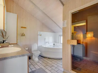 a bathroom with a tub and a toilet and a sink at Holiday Home Lovisa - 500m from the sea by Interhome in Løkken