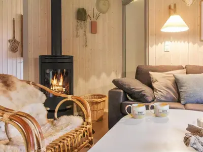 a living room with a couch and a fireplace at Holiday Home Lovisa - 500m from the sea by Interhome in Løkken