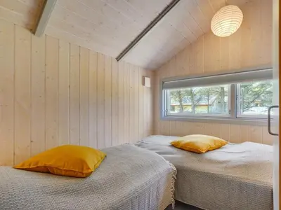 two beds in a room with a window at Holiday Home Lovisa - 500m from the sea by Interhome in Løkken