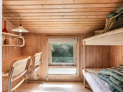 a room with a bed and chairs and a window at Holiday Home Estefania - 450m from the sea by Interhome in Løkken