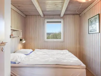a bed in a room with a window at Holiday Home Estefania - 450m from the sea by Interhome in Løkken