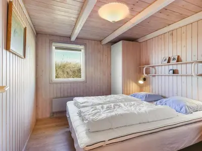 a bedroom with a large bed and a window at Holiday Home Estefania - 450m from the sea by Interhome in Løkken