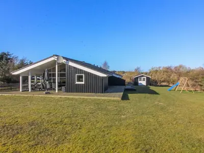 a house with a large yard with a playground at Holiday Home Nynke - 600m from the sea by Interhome in Løkken