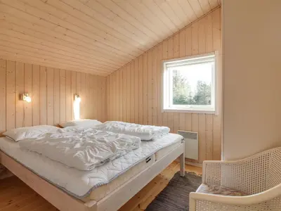 a bedroom with a bed in a room with a window at Holiday Home Nynke - 600m from the sea by Interhome in Løkken