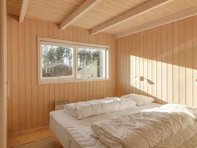 two beds in a room with a window at Holiday Home Nynke - 600m from the sea by Interhome in Løkken