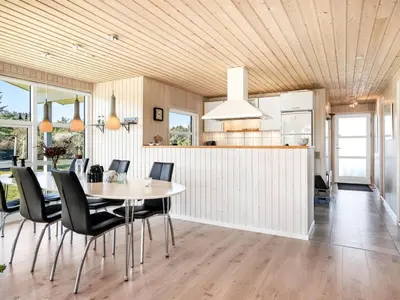 a kitchen and dining room with a table and chairs at Holiday Home Troels - 750m from the sea by Interhome in Løkken